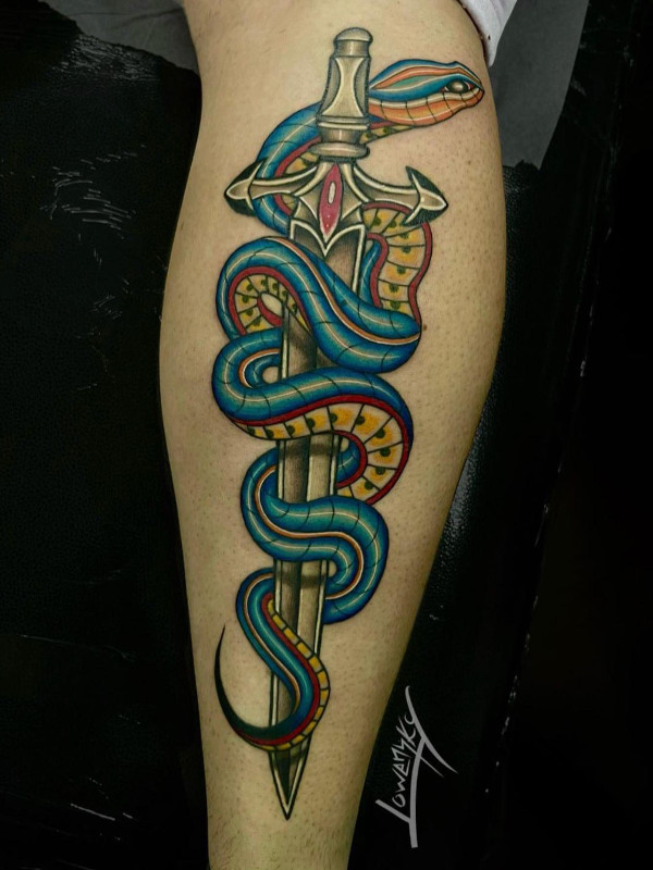 Calf tattoo of a blue snake coiled around a sword with a red ruby in the hilt tattooed by Lowensky Santiago of Sacred Mandala Studio in Durham, NC.